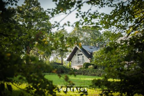 a house in the middle of a field with trees at Hubertus in Polanica-Zdrój