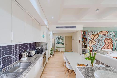 a kitchen and living room with a large mural on the wall at #1101 Cartwright - Chic Downtown Apartment in Cape Town