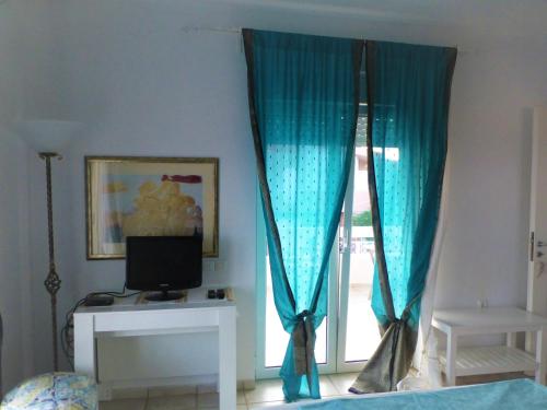 a room with a window with blue curtains at Seaview near Athens & Sounio in Anavissos