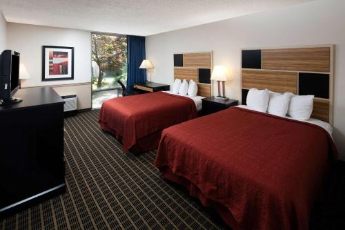 a hotel room with two beds and a flat screen tv at Red Lion Hotel Ellensburg in Ellensburg