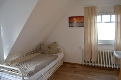シリヒにあるOldeoogweg 7bの窓付きの客室の小さなベッド1台分です。