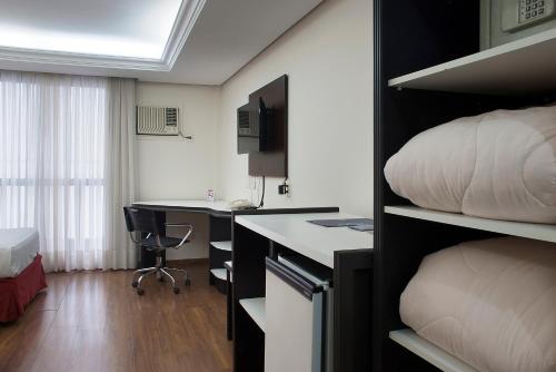 a hotel room with a bed and a desk and a room with a bed at Master Grande Hotel - Próximo ao Palácio do Governo in Porto Alegre