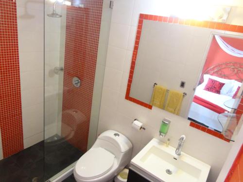 a bathroom with a toilet and a sink and a shower at Hotel Pueblito Playa in Cartagena de Indias