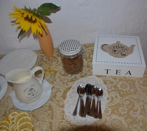 un tavolo con un servizio da tè con una tazza e un vaso di Agro Przy Kominku a Rozogi