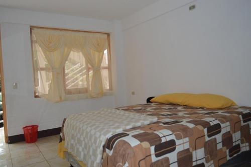 a bedroom with a bed and a window at Hotel Xetawaa´l in San Pedro La Laguna