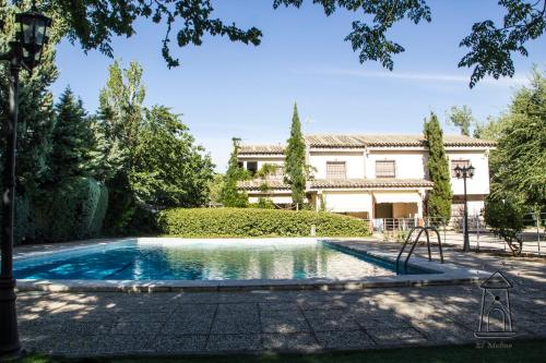 a swimming pool in front of a house at Finca El Molino in Ajofrín