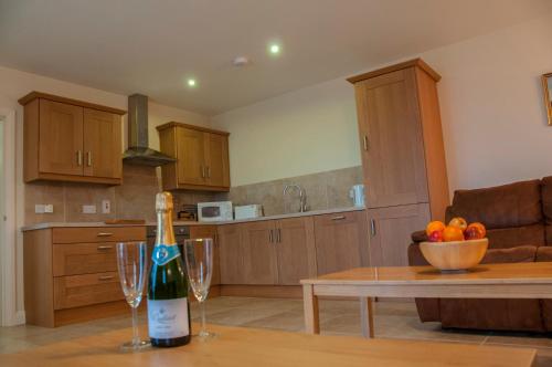 a bottle of wine sitting on a table in a kitchen at Finn Cottage in Strabane