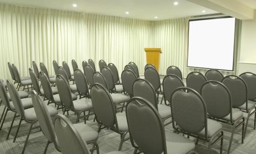 a row of chairs in a conference room with a screen at Hotel San Remo in Lima