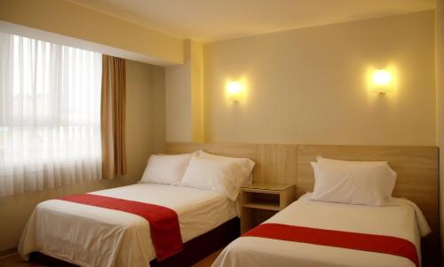 a hotel room with two beds and a window at Hotel San Remo in Lima