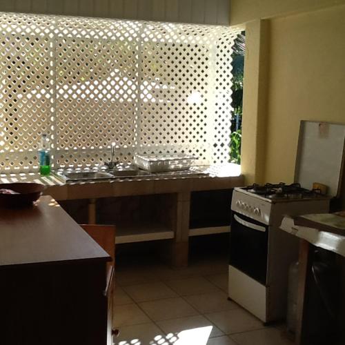a kitchen with a counter with a sink and a stove at Pension Turiroa " Chez Olga" in Avatoru