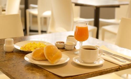 a table with two plates of food and a glass of orange juice at Hotel San Remo in Lima