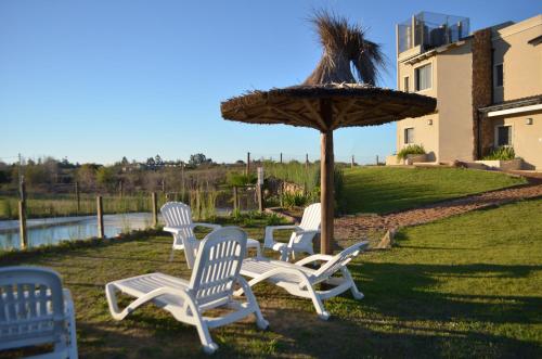 a group of lawn chairs and an umbrella at Rio y Piedras in Colón
