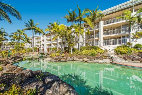 a resort with a swimming pool and palm trees at BreakFree Alexandra Beach in Alexandra Headland