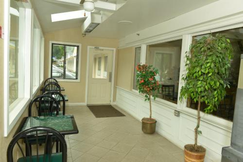 een veranda met stoelen en planten in een gebouw bij Whitney Inn & Suites in Hamden