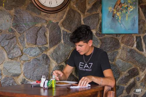 a man sitting at a table with a plate of food at Cabinas Vista Al Golfo in Monteverde Costa Rica