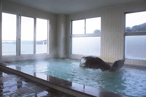 a large swimming pool with a whale in the water at Tabinoyado Ushionoakari Geiboso in Shima