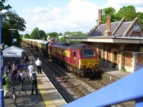 a train pulling into a train station with people waiting at Railway Inn in Culham