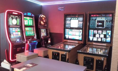 a room with three video game machines in a room at Le New Matinal in La Louvière