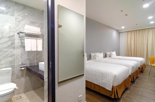 een hotelkamer met 2 bedden en een badkamer bij The Klagan Hotel in Kota Kinabalu
