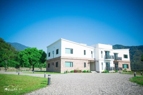 a large white building on a gravel driveway at Simple Life in Yuli