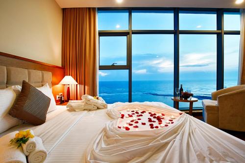 a bedroom with a large bed with a large window at Muong Thanh Holiday Ly Son in Ly Son