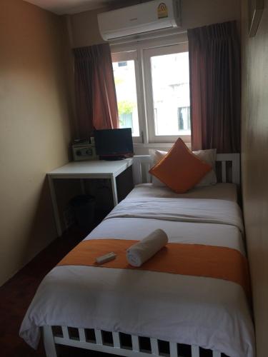 a small room with a bed and a window at VX The Fifty in Bangkok
