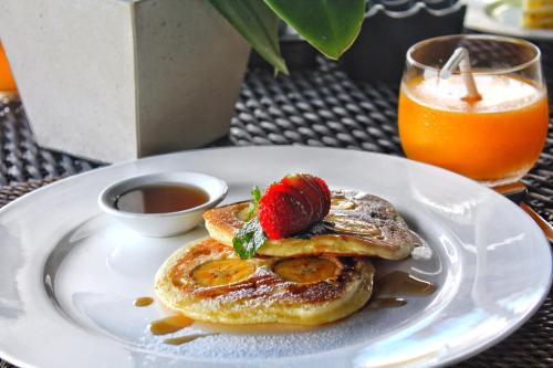 un piatto di pancake con fragole sopra di Hidden Hills Villas - Small Luxury Hotels of The World a Uluwatu