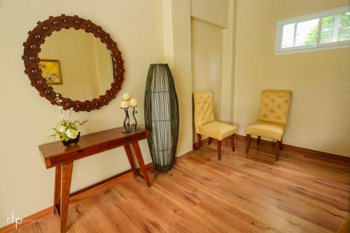 a room with a table and two chairs and a mirror at Balai Carmela in Tuguegarao City