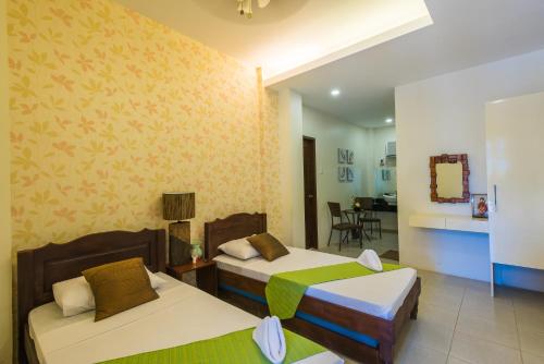 a bedroom with two beds and a living room at Balai Carmela in Tuguegarao City