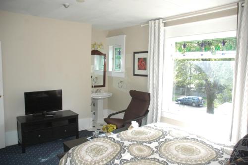 a bedroom with a bed and a window at Windsor Guest House in Vancouver