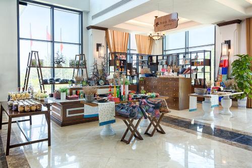 a store with tables and chairs in a room with windows at Muong Thanh Holiday Ly Son in Ly Son