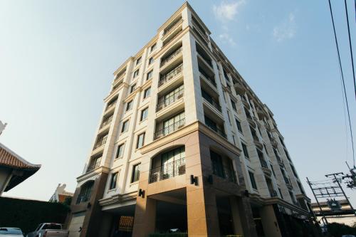 فندق طومسون ريزيدنس في بانكوك: مبنى أبيض طويل على شارع المدينة