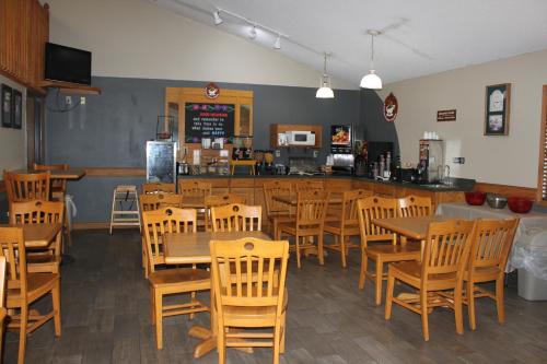 a restaurant with wooden tables and chairs and a counter at AmericInn by Wyndham West Burlington in West Burlington