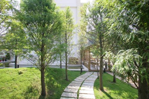 a walkway in a park with trees and a building at Xianel Vacation Chateau in Dahu