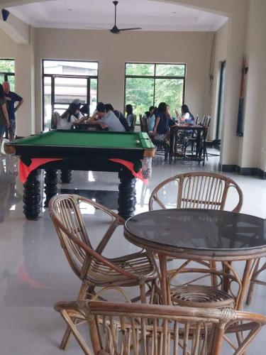 a pool table in a room with people sitting at tables at Blue Diamond Hostel in Battambang