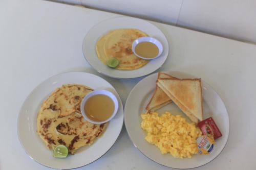 un tavolo con due piatti di cibo e due tazze di caffè di Bintang Beach Villa ad Amed