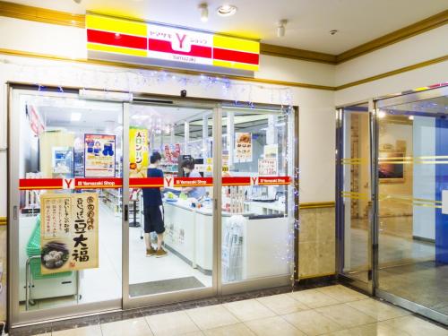 a woman standing in front of a store window at Hotel Merieges in Miyazaki