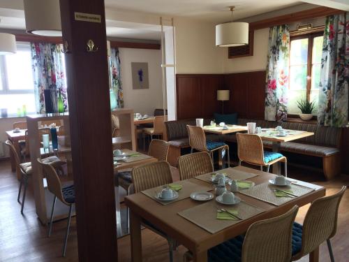 a restaurant with wooden tables and chairs and windows at Hotel Schober in Freiberg am Neckar