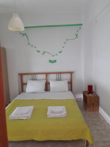 a bedroom with a green bed with two towels on it at Villagiannis in Nea Fokea