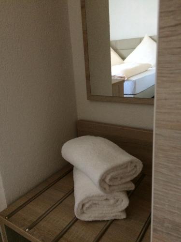 a towel sitting on a shelf in a bathroom with a mirror at Hotel Mezzero in Waldshut-Tiengen