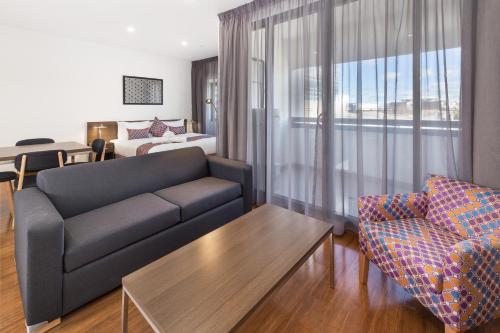 a living room filled with furniture and a window at City Edge Dandenong Apartment Hotel in Dandenong