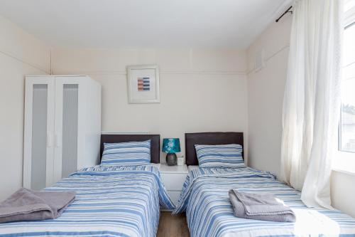 Säng eller sängar i ett rum på DAGENHAM 3 BEDROOMS2BATHS