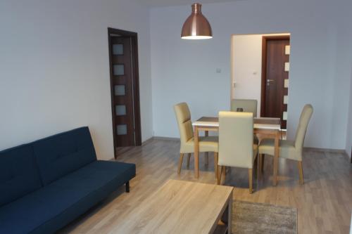 a living room with a couch and a table and chairs at Joy Apartment in Timişoara