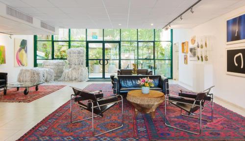 a living room with chairs and a couch and a table at Diaghilev LOFT live art hotel in Tel Aviv