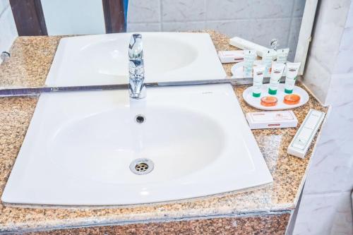 a bathroom counter with two white sinks and toothbrushes at Ganpati Hotel Katra in Katra