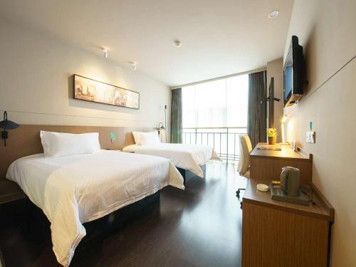 a hotel room with two beds and a television at Jinjiang Inn Pinshang Xi'an South 2nd Ring Hi-Tech Development Zone in Xi'an