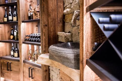 a wine cellar with a stone sink and wine bottles at Apartment Lodge Gasserhof in Bressanone