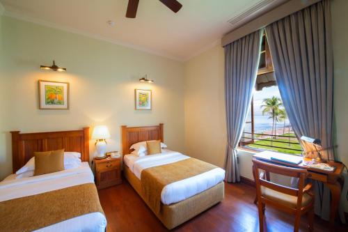 Habitación de hotel con 2 camas y ventana en Galle Face Hotel en Colombo