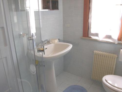 a white bathroom with a sink and a shower at Villa San Marco- via Carducci in Grado