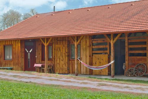 a wooden cabin with a hammock in front of it at Kerca Bio Farm in Kercaszomor